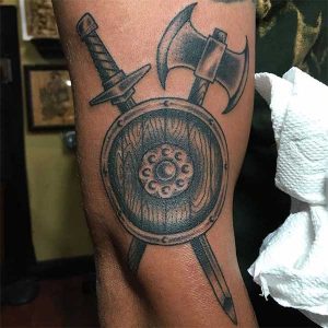 tatuaje-armas-vikingas-escudo-espada-hacha-brazo
